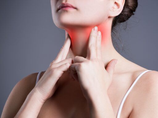 Mujer tocándose la zona tiroidea del cuello, destacada en rojo para representar síntomas relacionados con el hipertiroidismo.