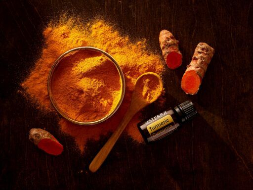 Cúrcuma en polvo con raíces frescas y frasco de extracto de curcumina sobre fondo oscuro, utilizada como antiinflamatorio natural para el dolor articular.