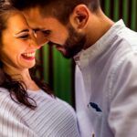 Pareja sonriente en actitud cercana que refleja un vínculo de amor consciente, libre y conectado emocionalmente.