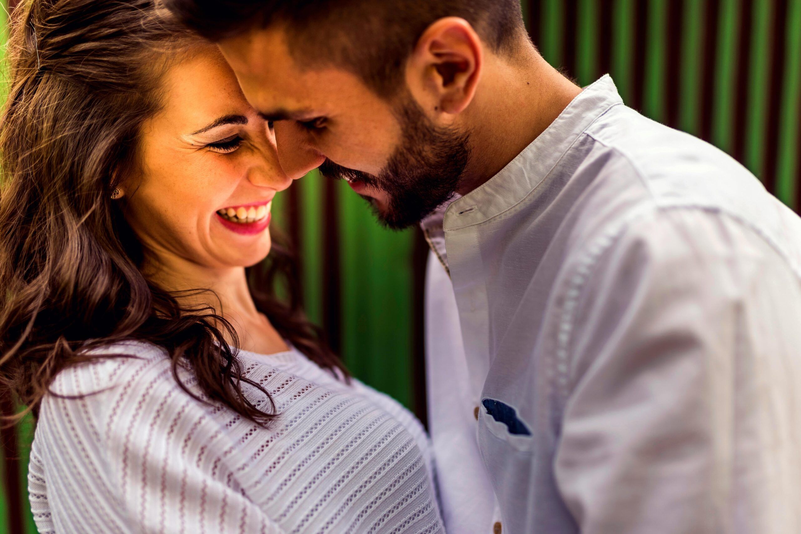 Pareja sonriente en actitud cercana que refleja un vínculo de amor consciente, libre y conectado emocionalmente.