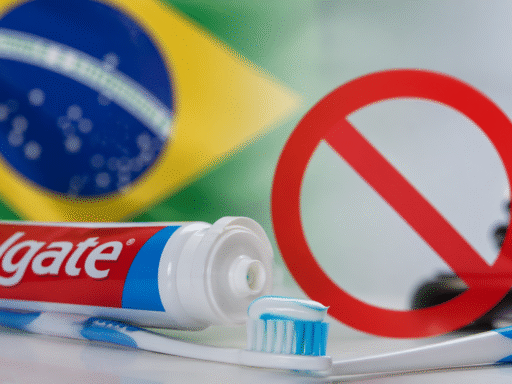 Pasta dental Colgate con cepillo de dientes y bandera de Brasil al fondo, simbolizando la polémica sobre su posible prohibición.