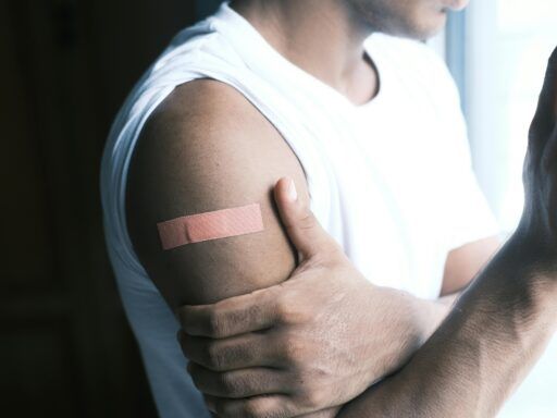 Hombre con una tirita adhesiva en el brazo ilustrando el uso de productos sanitarios y la posible exposición a químicos.