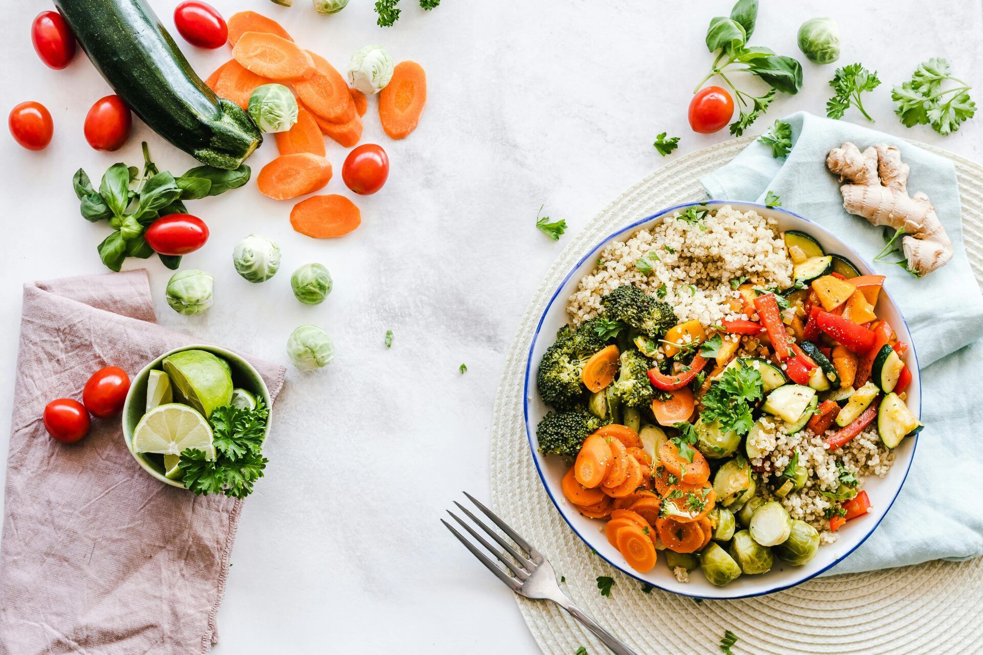 Plato saludable con quinoa y verduras frescas: brócoli, zanahorias, calabacín, pimientos y coles de Bruselas, representando bienestar y nutrición consciente.