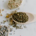 Primer plano de cucharas de madera con manzanilla, lavanda y otras hierbas secas usadas para infusiones relajantes contra la ansiedad.