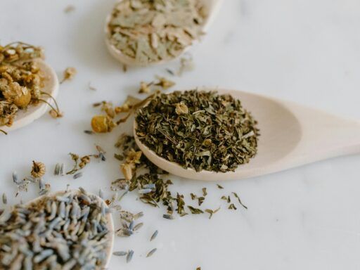 Primer plano de cucharas de madera con manzanilla, lavanda y otras hierbas secas usadas para infusiones relajantes contra la ansiedad.