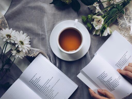 Taza de té natural para dormir profundamente junto a libros y flores, ideal para mejorar el sueño.