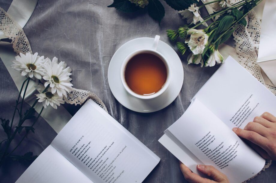 Taza de té natural para dormir profundamente junto a libros y flores, ideal para mejorar el sueño.