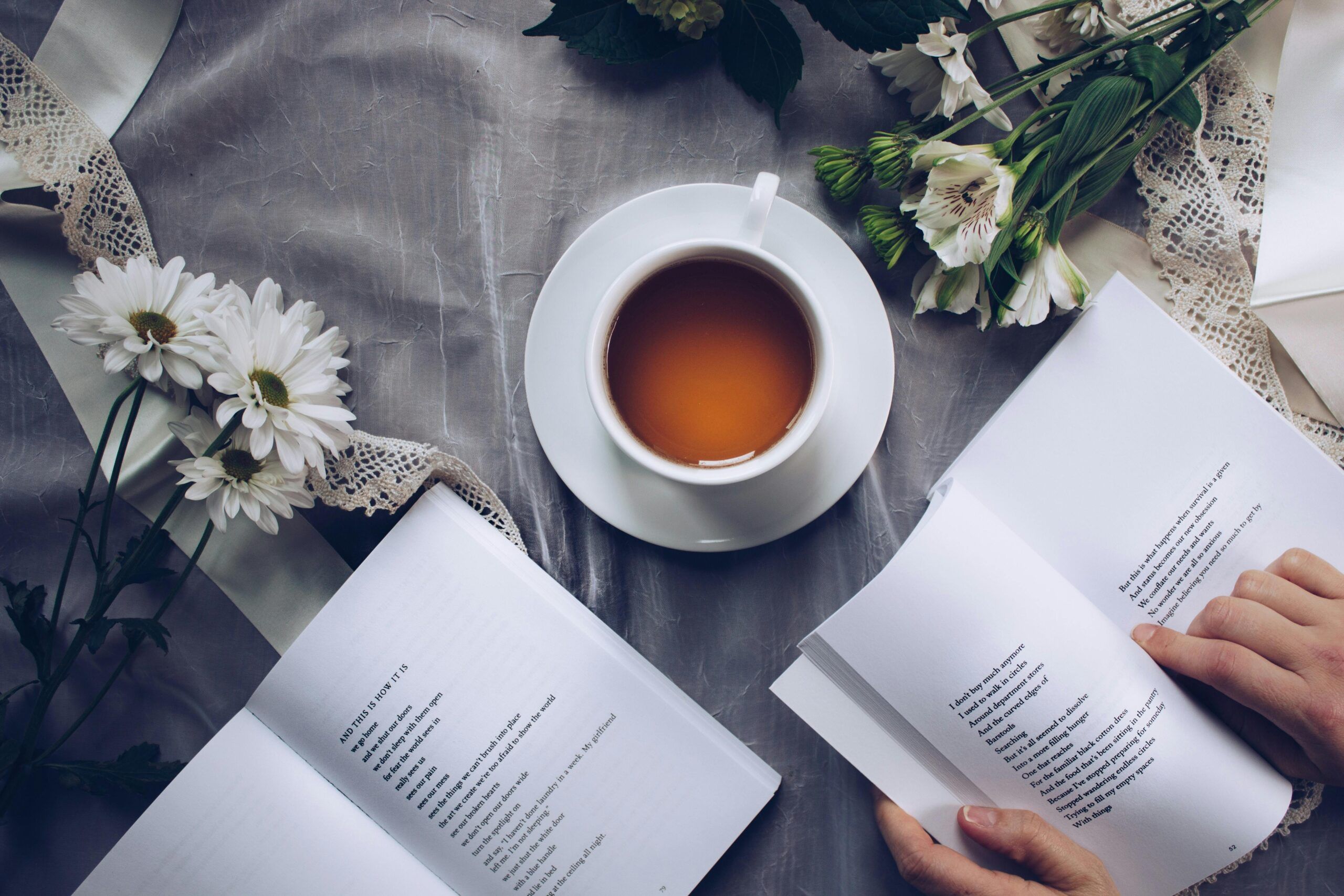 Taza de té natural para dormir profundamente junto a libros y flores, ideal para mejorar el sueño.
