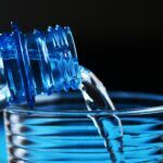 Botella de agua de plástico con partículas de microplásticos, ilustrando la contaminación en agua embotellada.