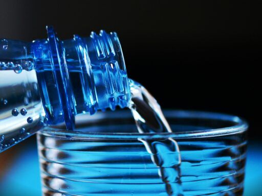 Botella de agua de plástico con partículas de microplásticos, ilustrando la contaminación en agua embotellada.