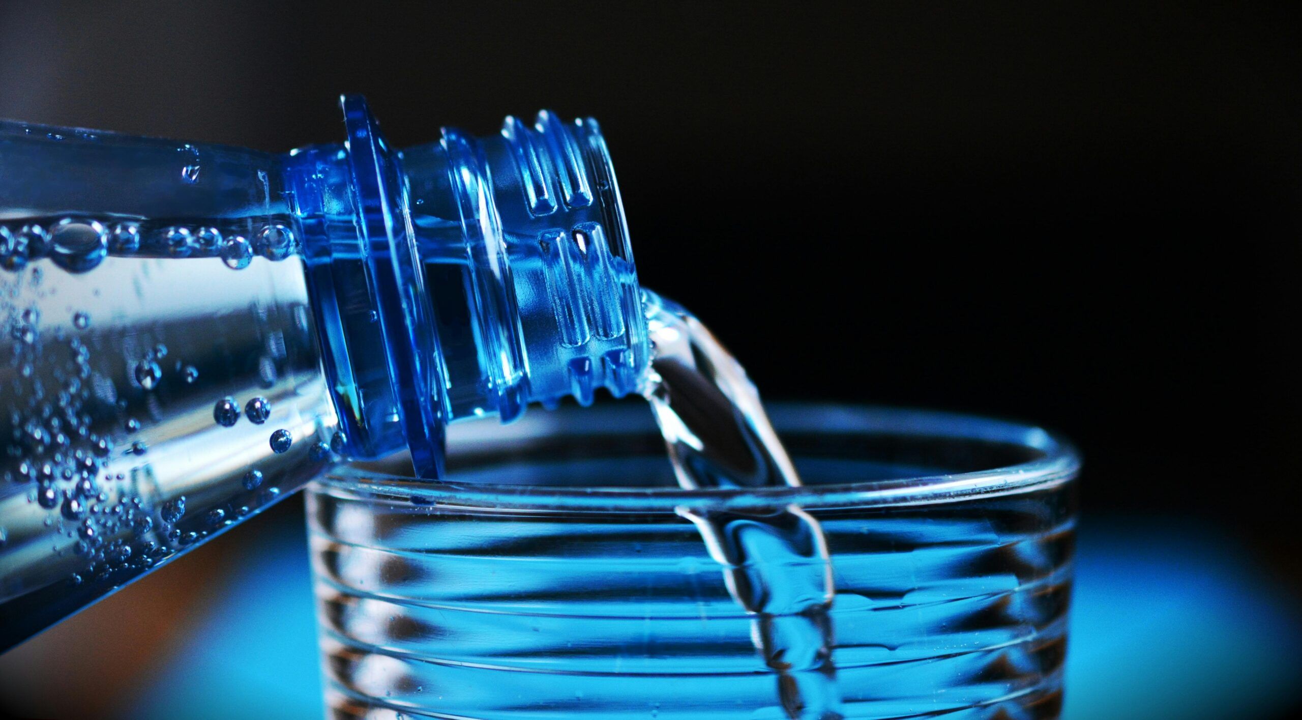 Botella de agua de plástico con partículas de microplásticos, ilustrando la contaminación en agua embotellada.