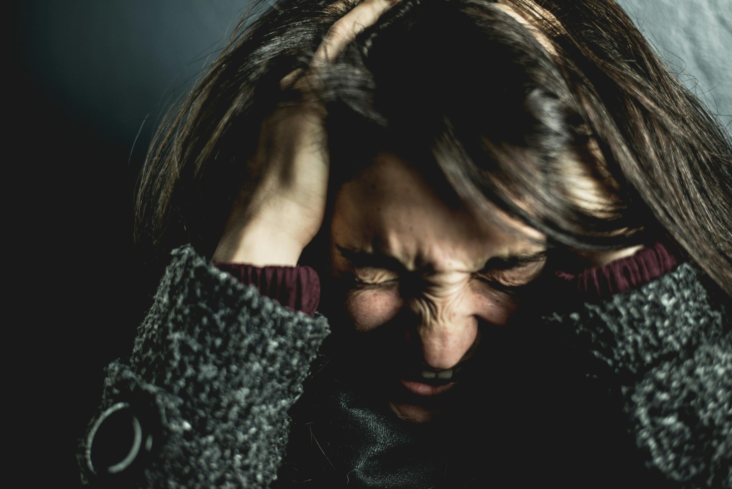 Mujer con gesto de angustia y las manos en la cabeza, mostrando tensión y sobrecarga emocional típica del estrés crónico.