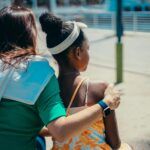 Mujer acompañando con el brazo a una niña en un gesto de apoyo, simbolizando el vínculo, la contención y el proceso emocional en la adopción desde la mirada de las constelaciones familiares.