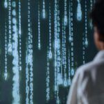 Persona observando flujos de datos digitales como metáfora del campo neuronal y la conciencia interconectada según Jacobo Grinberg.
